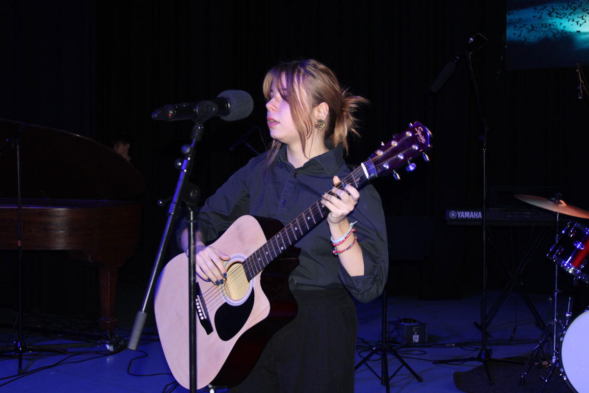 A female student playing guitar at the East Barnet School Winter Concert.