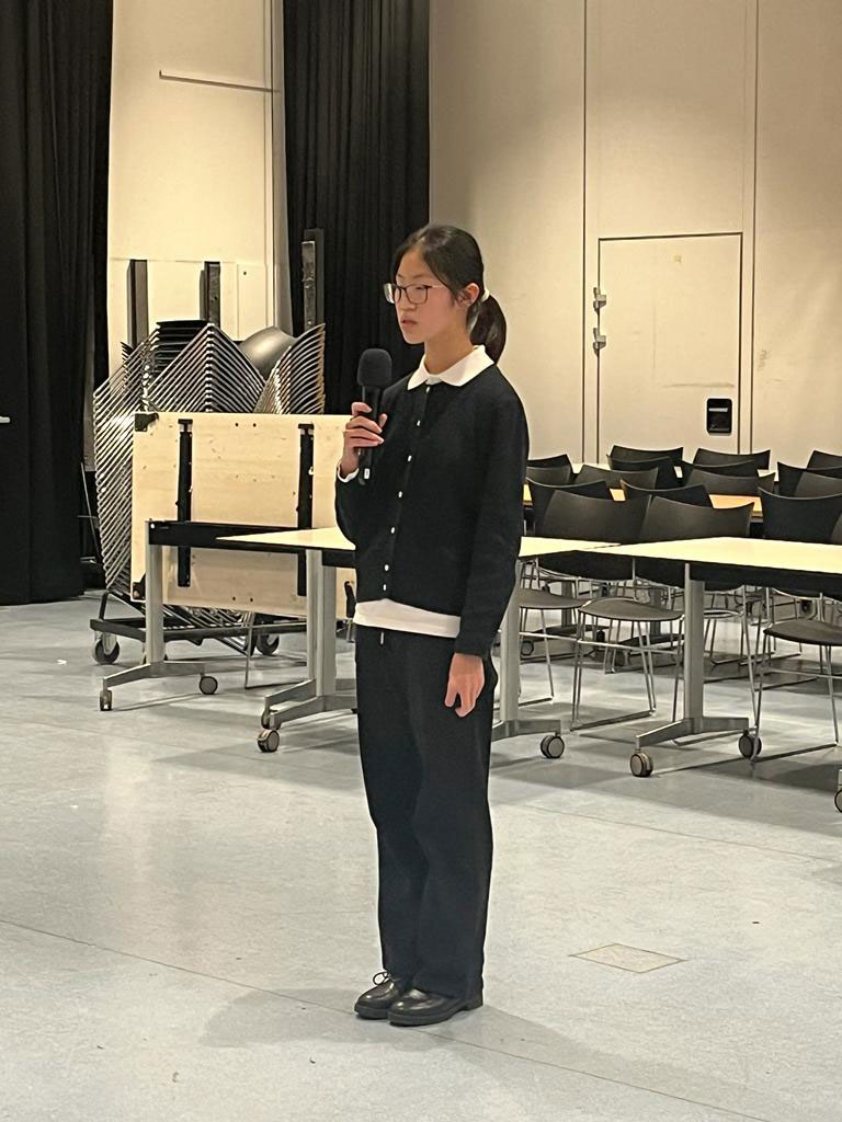 a chinese student visitor to east barnet school talking to the audience
