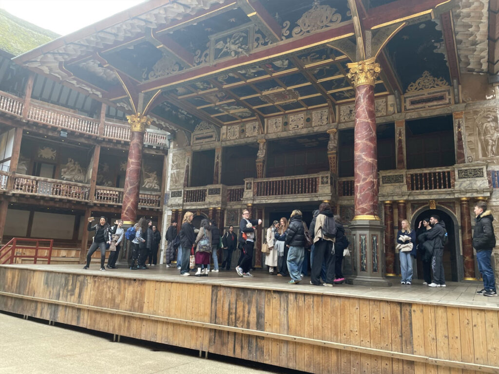 students from east barnet school stood on the stage at the globe