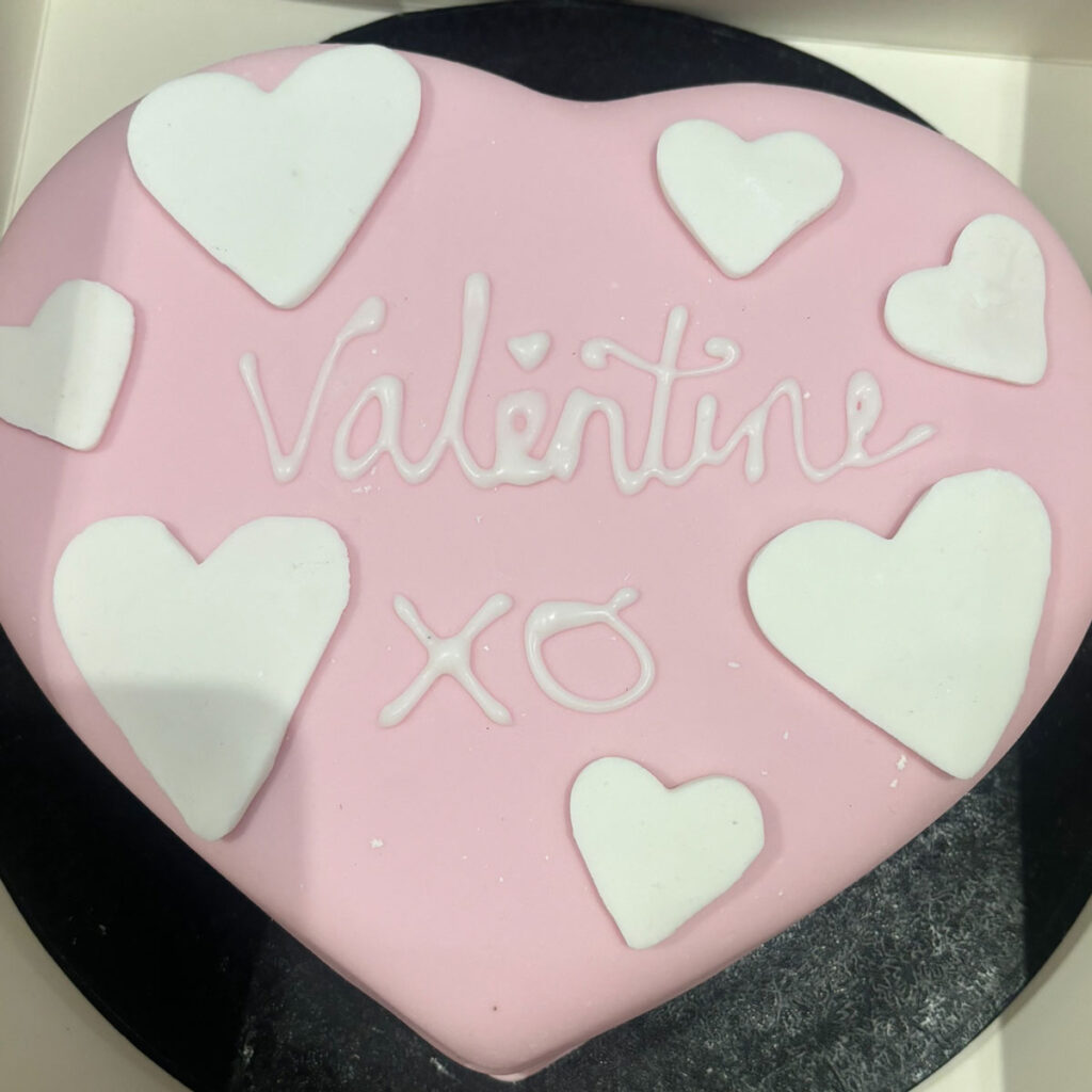 a pink heart shaped cake with hearts and the word valentine on top for the ebs cake competition