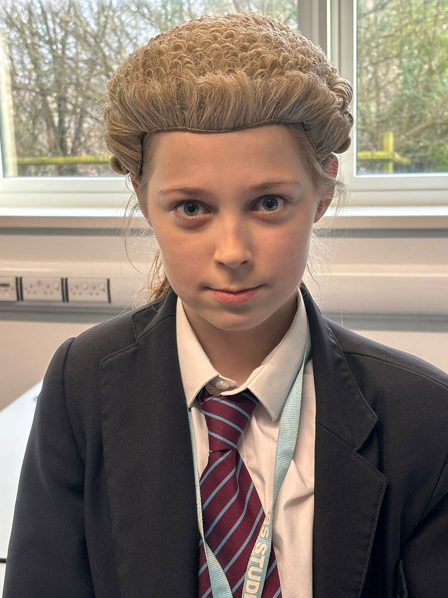 an ebs student wearing a judges wig whilst preparing for a mock trial