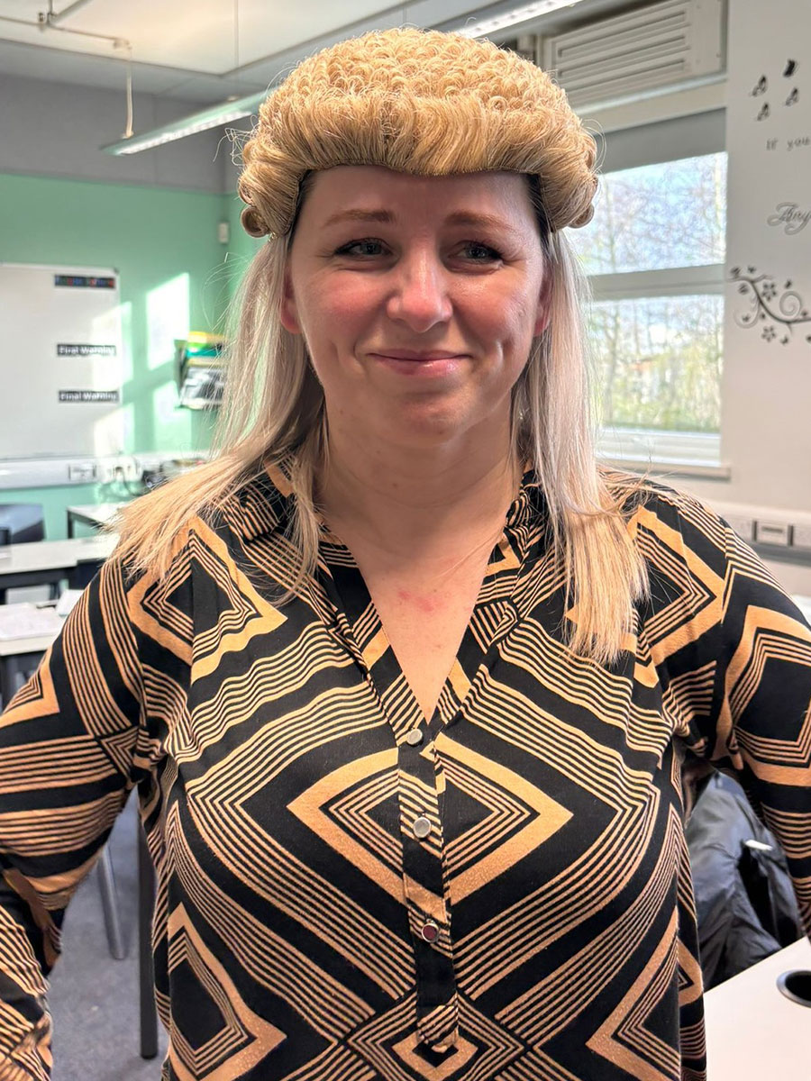 an ebs staff member wearing a judges wig whilst preparing for a mock trial