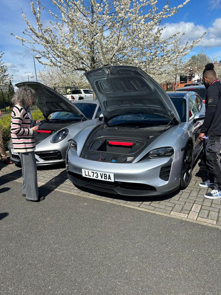 students looking at a porsche during a careers talk