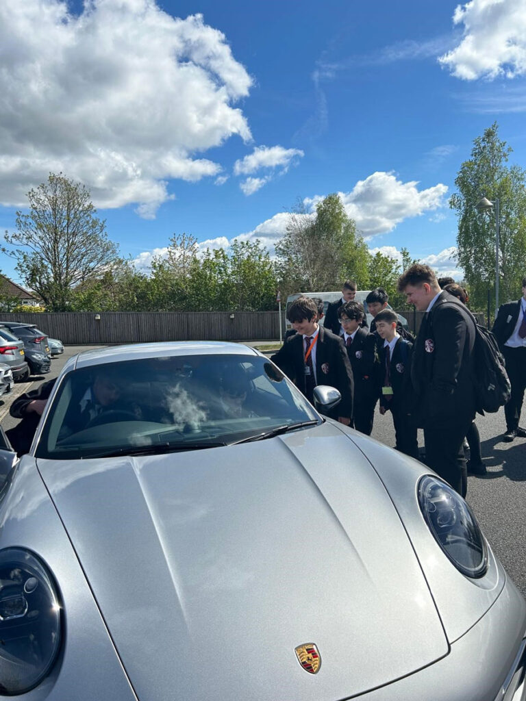 students looking at a porsche during a careers talk